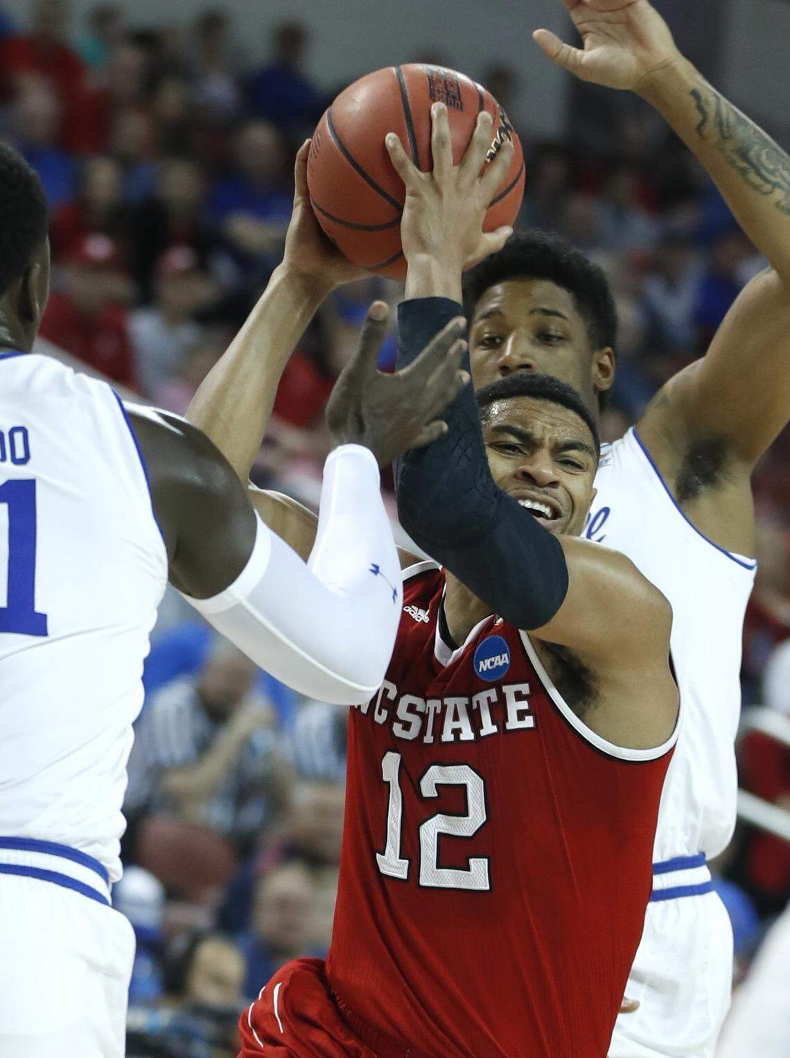 N.C. State's Allerik Freeman (12) drives between Seton Hall's Desi Rodriguez (20), back, and Angel Delgado (31) during the first half of N.C. State's game against Seton Hall in the first round of the 2018 NCAA Men's Basketball Championship at INTRUST Bank Arena in Wichita, Kan., Thursday, March 15, 2018.