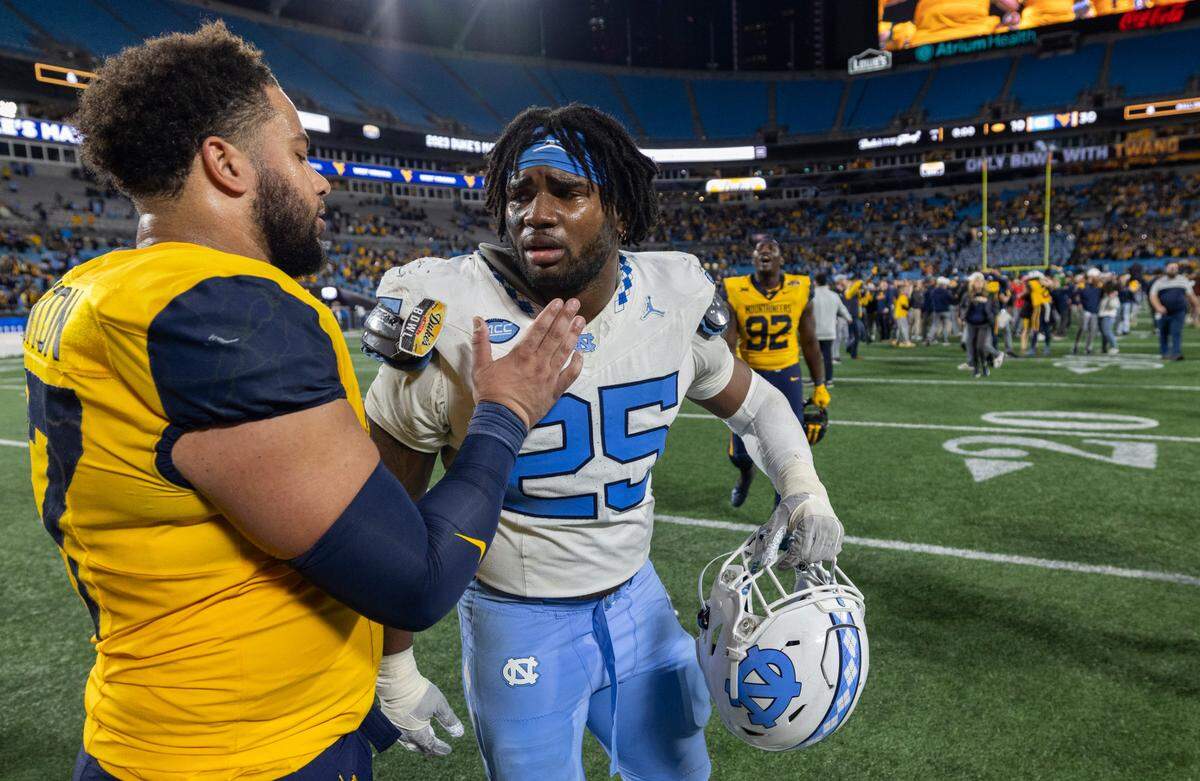 West Virginia’s Thornton Jalen (87) consoles North Carolina’s Kaimon Rucker (25) following the Mountaineers’ 30-10 victory in the Duke’s Mayo Bowl on Wednesday, December 27, 2023 at Bank of American Stadium in Charlotte, N.C.