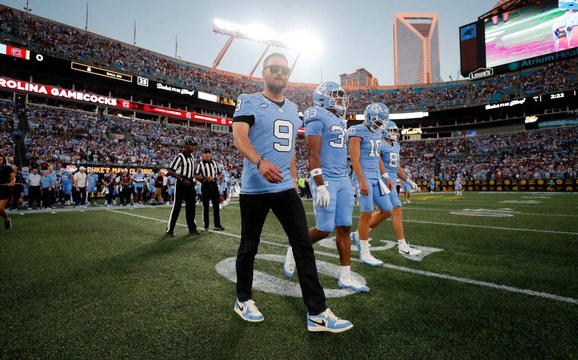 Eric Church, wearing Tez Walker’s jersey, walks out with the captains for the coin toss before UNC’s game against South Carolina in the Duke’s Mayo Classic at Bank of America Stadium in Charlotte, N.C., Saturday, Sept. 2, 2023.