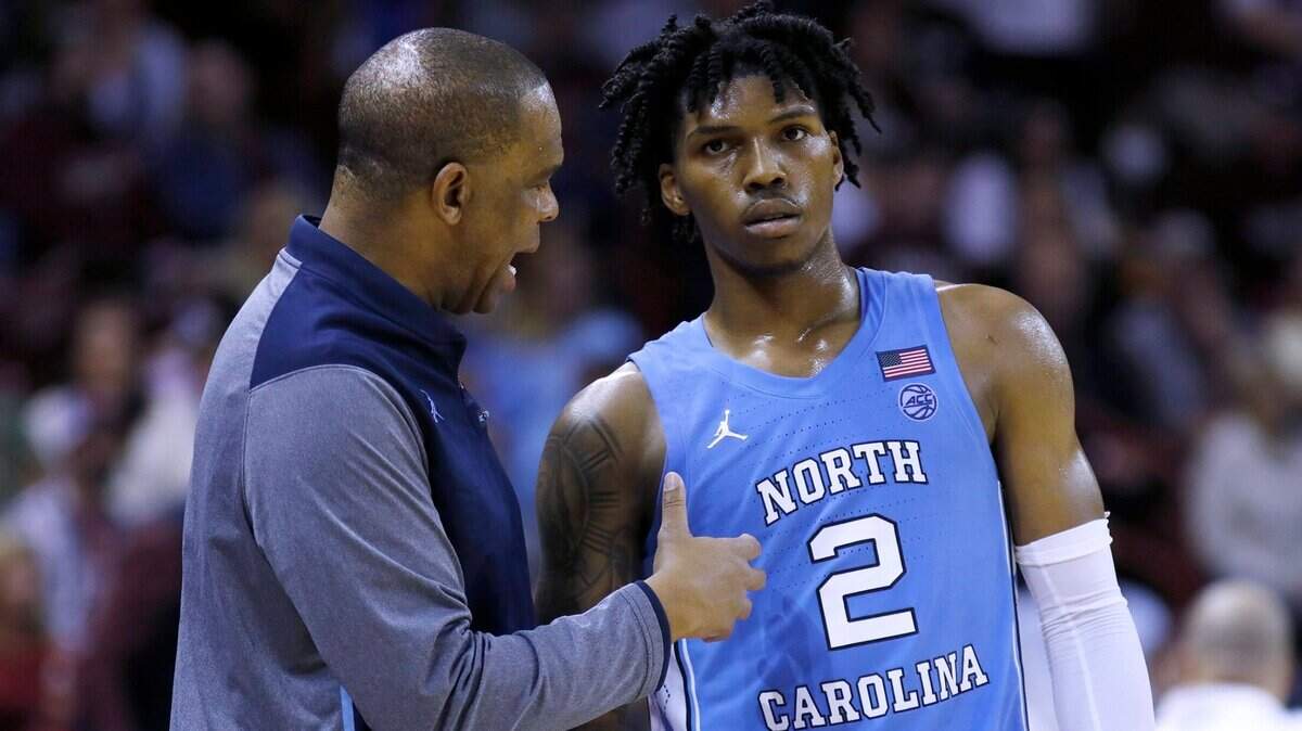 North Carolina coach Hubert Davis talks to Caleb Love (2) during the team’s NCAA basketball game against College of Charleston, during the second half Tuesday, Nov. 16, 2021, in Charleston, S.C. (AP Photo/Mic Smith)