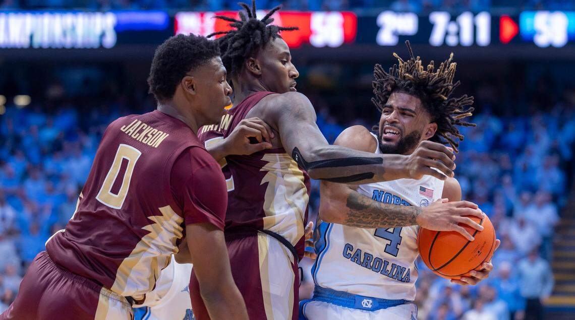 Florida State’s Chandler Jackson (0) and Jamir Watkins (2) defend North Carolina’s R.J. Davis (4) in the second half on Saturday, December 2, 2023 at the Smith Center in Chapel Hill, N.C. Davis lead all scores with 27 points in the Tar Heels’ 78-70 victory.