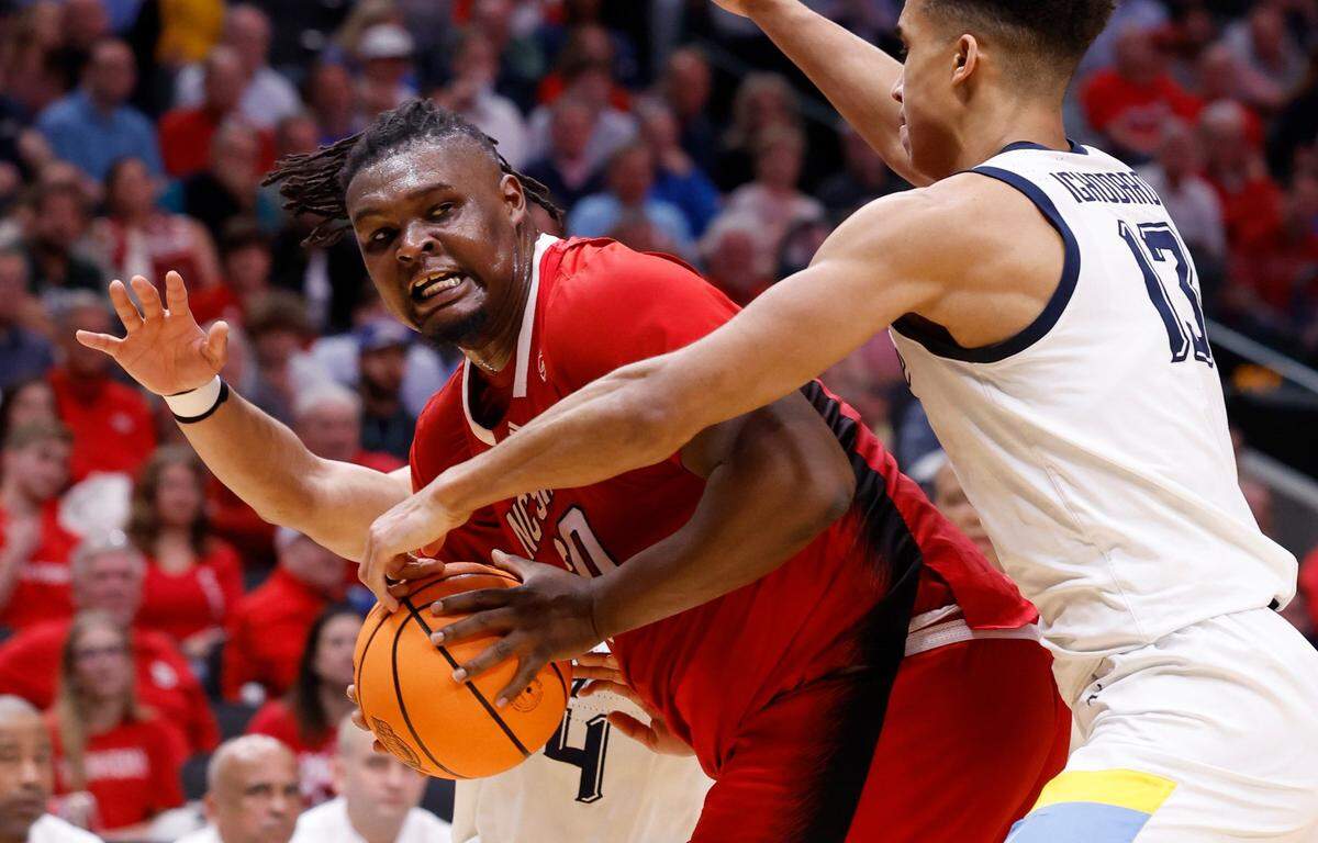 Duke’s Kyle Filipowski (30) passes out of the defense by Marquette’s Oso Ighodaro (13) and Stevie Mitchell (4) during the second half of N.C. State’s 67-58 victory over Marquette in their NCAA Tournament Sweet 16 game at the American Airlines Center in Dallas, Texas, Friday, March 29, 2024.