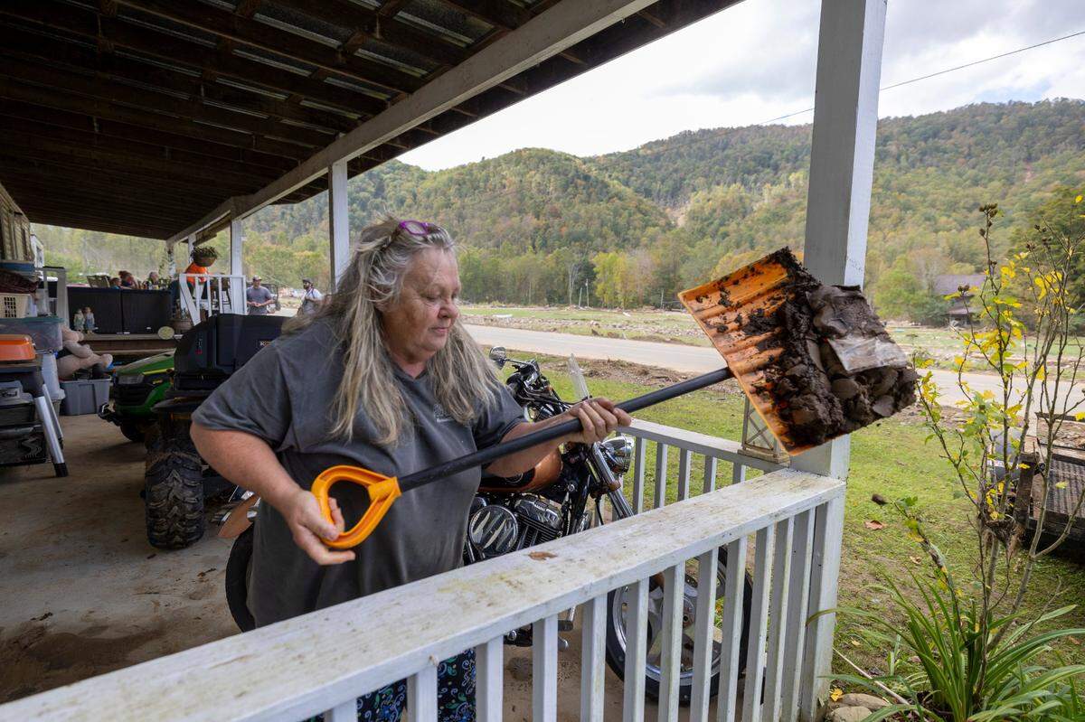 Joyce Maness shovels mud, laced with sewage, from her front porch in the Pensacola community of Yancey County, N.C. on Thursday, October 3, 2024 in Pensacola, N.C. Food waters from Hurricane Helene pushed the mud and sewage into her home.