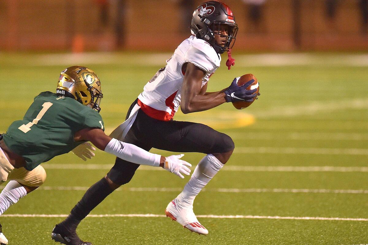 Rolesville’s Noah Rogers (5) runs for yardage against Cardinal Gibbons’ Will Mason (1) during the second half. The Cardinal Gibbons Crusaders and the Rolesville Rams met in the NCHSAA 4A East Regional Final in Raleigh, N.C. on December 3, 2021