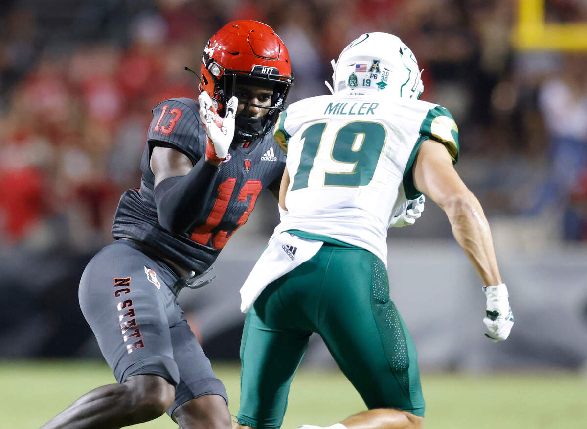 N.C. State linebacker Tyler Baker-Williams (13) defends South Florida wide receiver Bryce Miller (19) during the first half of N.C. State’s game against USF at Carter-Finley Stadium in Raleigh, N.C., Thursday, Sept. 2, 2021.
