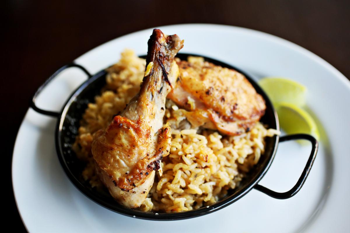 Chef Roberto Copa Matos of COPA calls on his Spanish heritage for his distinctive presentation of the Cuban classic, arroz con pollo. Taking a cue from paella, he first browns bone-in chicken legs and thighs skin-side down in a paella pan, then turns them so that the skin remains exposed above the level of the rice and chicken broth that he adds to the pan.