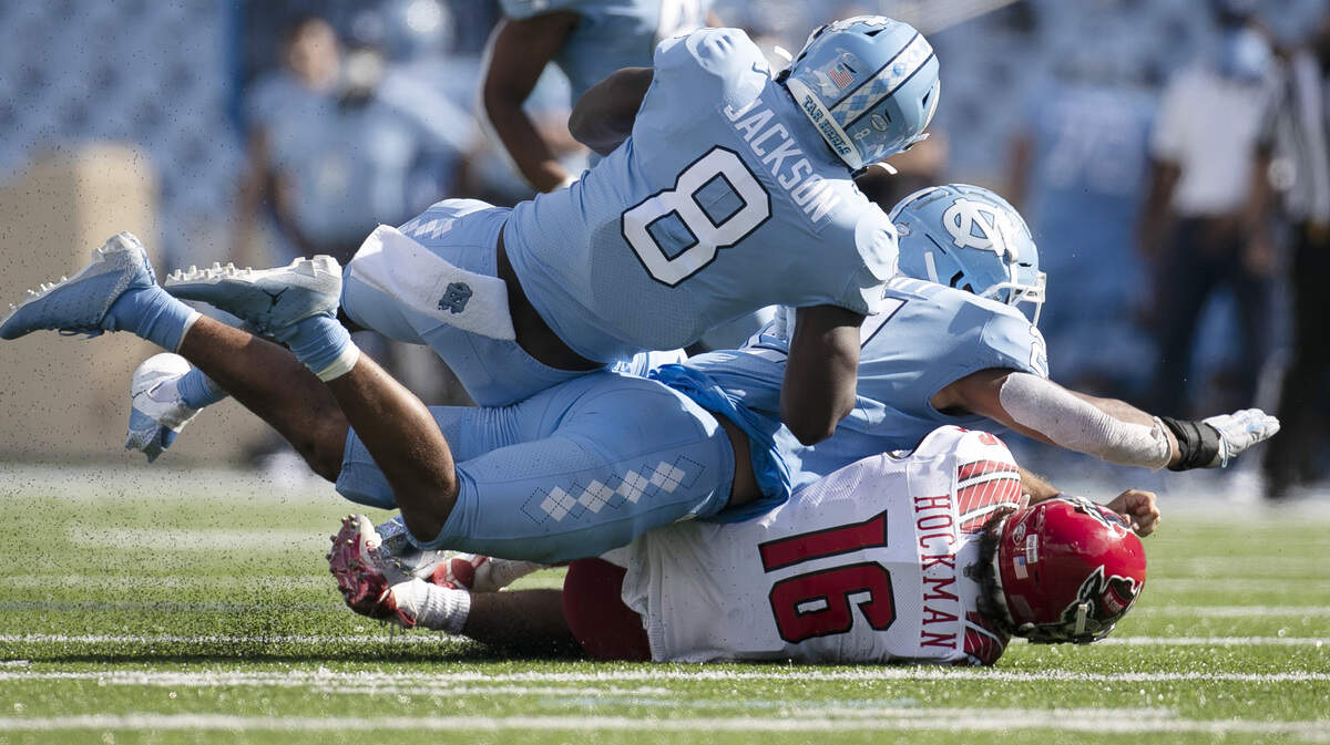 N.C. State quarterback Bailey Hockman (16) is sacked by North Carolina’s Chazz Surratt (21) and Khadry Jackson (8) in the fourth quarter at Kenan Stadium on Saturday, October 24, 2020 in Chapel Hill, N.C.