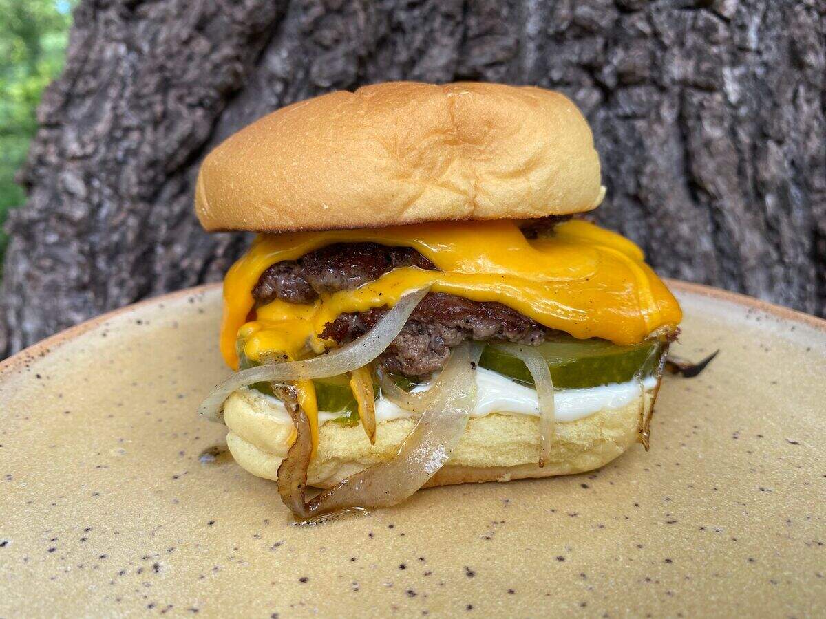 The Durham cocktail bar Kingfisher became the backyard burger pop-up Queen Burger. Pictured is the Queen Burger take on a cheeseburger, with griddled patties and onions, hoop cheese, pickles and a healthy smear of Duke’s mayonnaise.