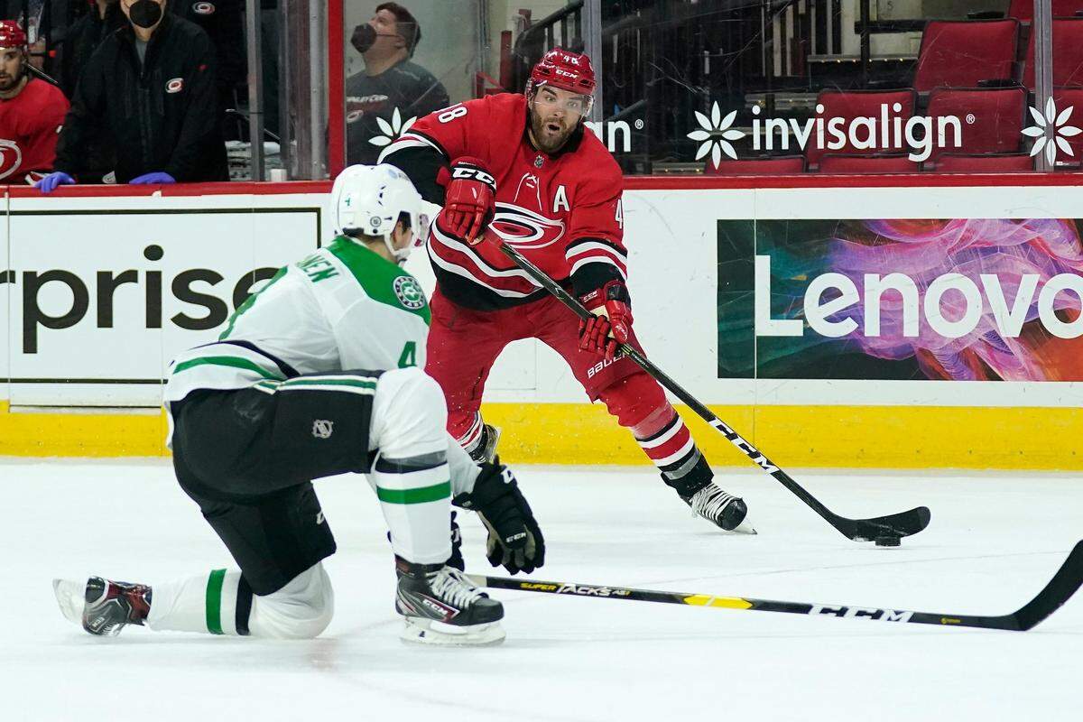 Carolina Hurricanes left wing Jordan Martinook (48) shoots while Dallas Stars defenseman Miro Heiskanen (4) defends during the second period of an NHL hockey game in Raleigh, N.C., Sunday, April 4, 2021. (AP Photo/Gerry Broome)