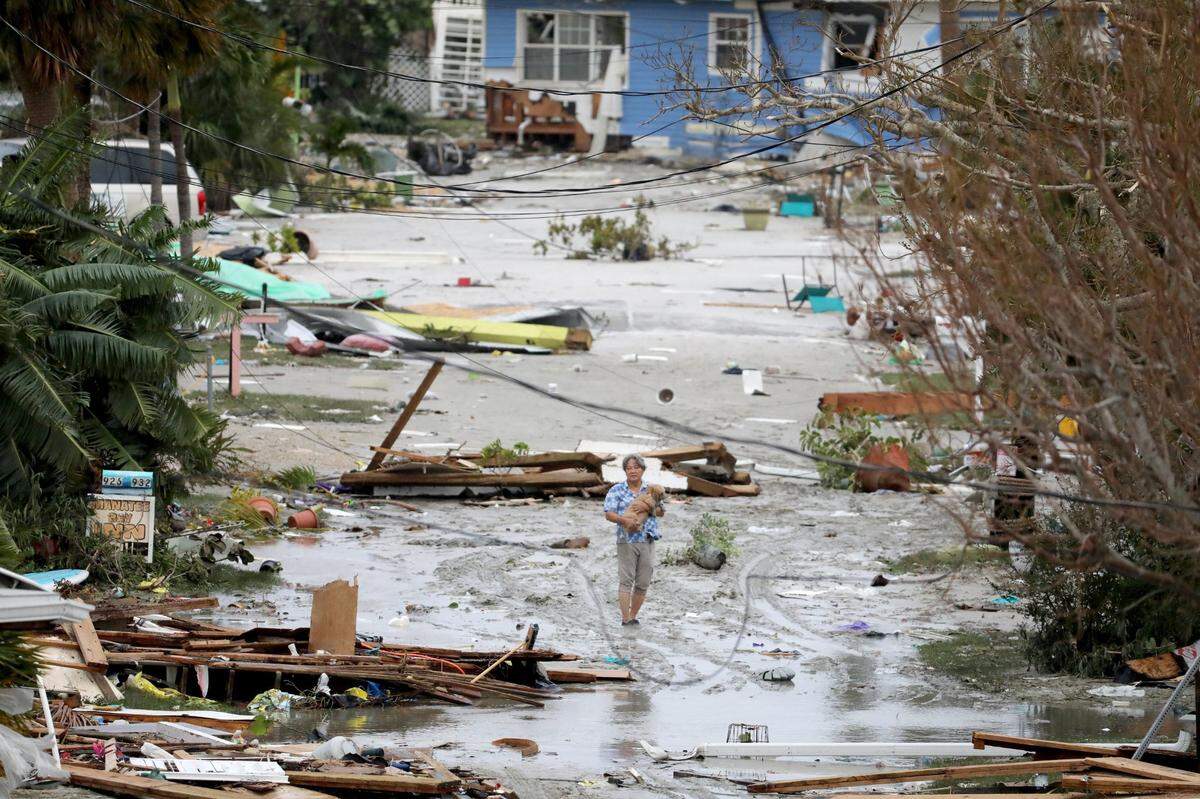 Pat Ton, holding his dog Ginger, takes in the damage to homes and businesses on 3rd Street at Fort Myers Beach on Thursday, Sep. 29, 2022, which was mostly destroyed after Hurricane Ian made landfall overnight on Wednesday.