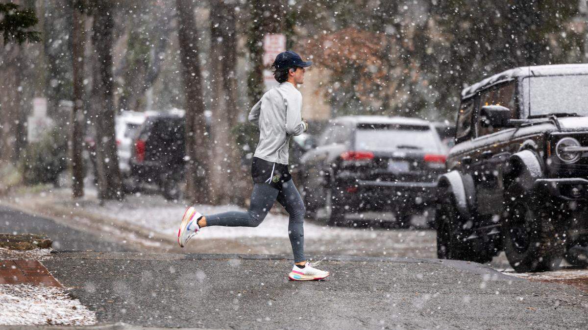 A runner braves the freezing temperature as snow begins to fall near UNC-Chapel Hill on Wednesday, Feb. 19, 2024.