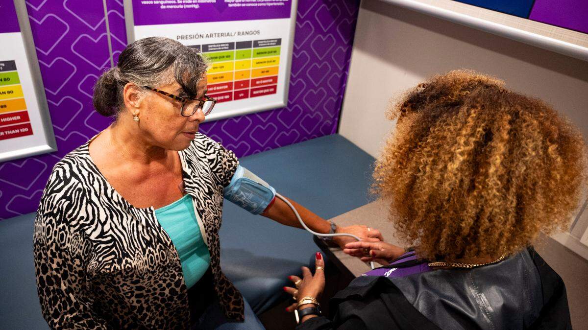 Lisa Hanif-Baldwin has her blood pressure monitored by Yohanny Moncion inside the Aetna bus in Raleigh on Thursday, July 25, 2024.
