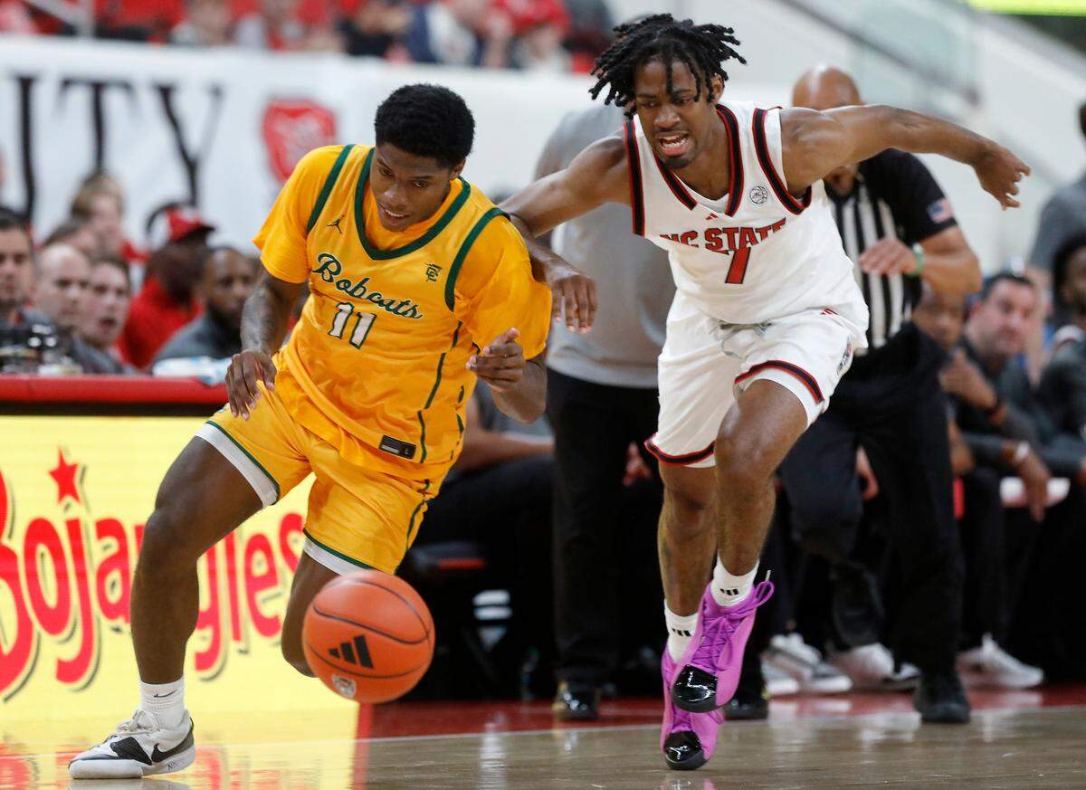 Lees-McRae’s Ja’Quavian Florence and N.C. State’s Bryce Heard chase after a loose ball during the first half of the Wolfpack’s 79-75 exhibition win on Wednesday, Oct. 30, 2024, at the Lenovo Center.