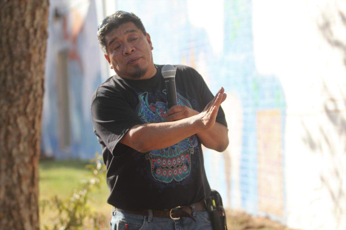 Durham muralist Cornelio Campos talks about his new mural in Lakewood, which a few dozen people helped paint Saturday. The mural updates an original mural from 1998 and features the message “Welcome home” in both English and Spanish.