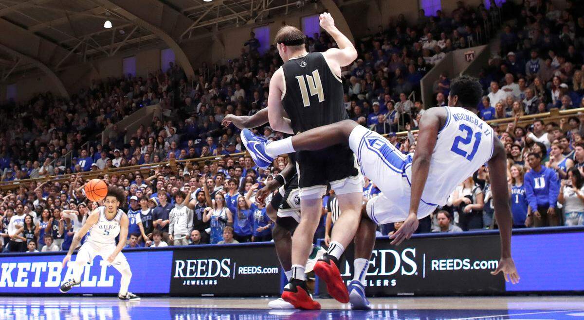 Duke’s Patrick Ngongba II (21) falls to the ground after knocking the rebound to Tyrese Proctor (5) during Duke’s 86-35 victory over Wofford at Cameron Indoor Stadium in Durham, N.C., Saturday, Nov. 16, 2024.