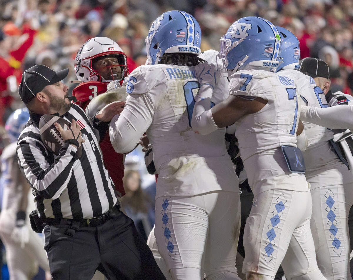 Official Jake Dishaw works to separate N.C. State running back Hollywood Smothers (3) from North Carolina defense tackle D’Antre Robinson Jr. (6) late in the second quarter on Saturday, November 29, 2025, at Carter-Finley Stadium in Raleigh, N.C.