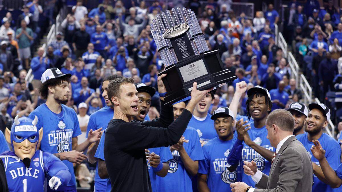 Duke head coach Jon Scheyer holds up the championship trophy after Duke’s 59-49 victory over Virginia to win the ACC Men’s Basketball Tournament in Greensboro, N.C., Saturday, March 11, 2023.