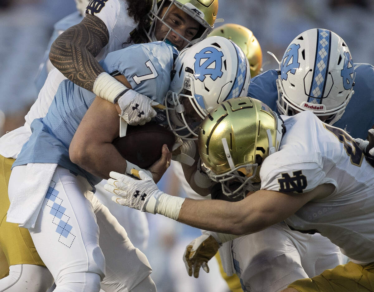 North Carolina quarterback Sam Howell (7) is sacked by Notre Dame’s Marist Liufau (35) and Drew White (40) in the second quarter on Friday, November 27, 2020 at Kenan Stadium in Chapel Hill, N.C.