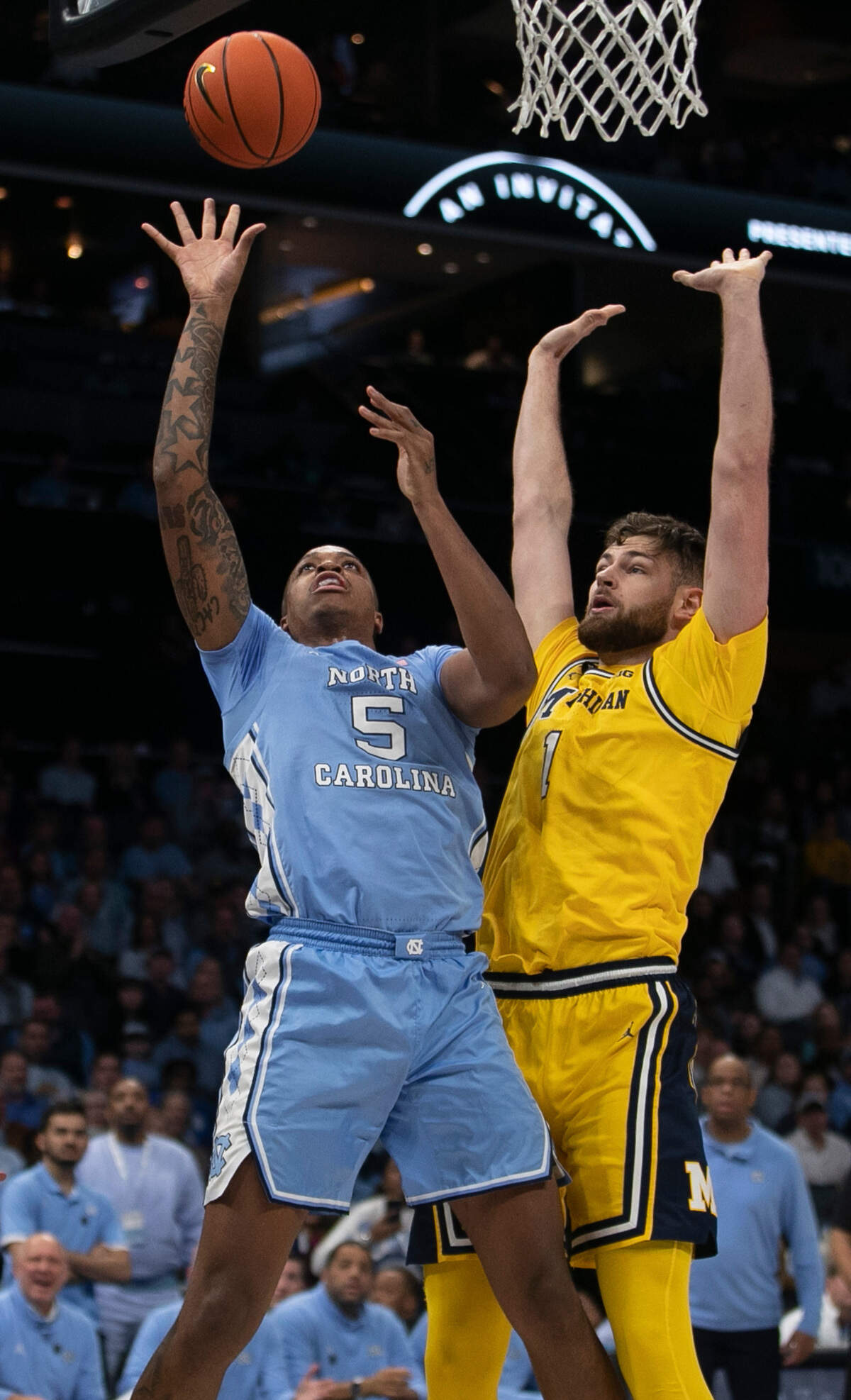 North Carolina’s Armando Bacot (5) muscles his way to the basket against Michigan’s Hunter Dickinson (1) in the second half on Wednesday, December 21, 2022 at the Spectrum Center in Charlotte, N.C. Bacot lead all scores with 26 points in the Tar Heels’ 80-76 victory.