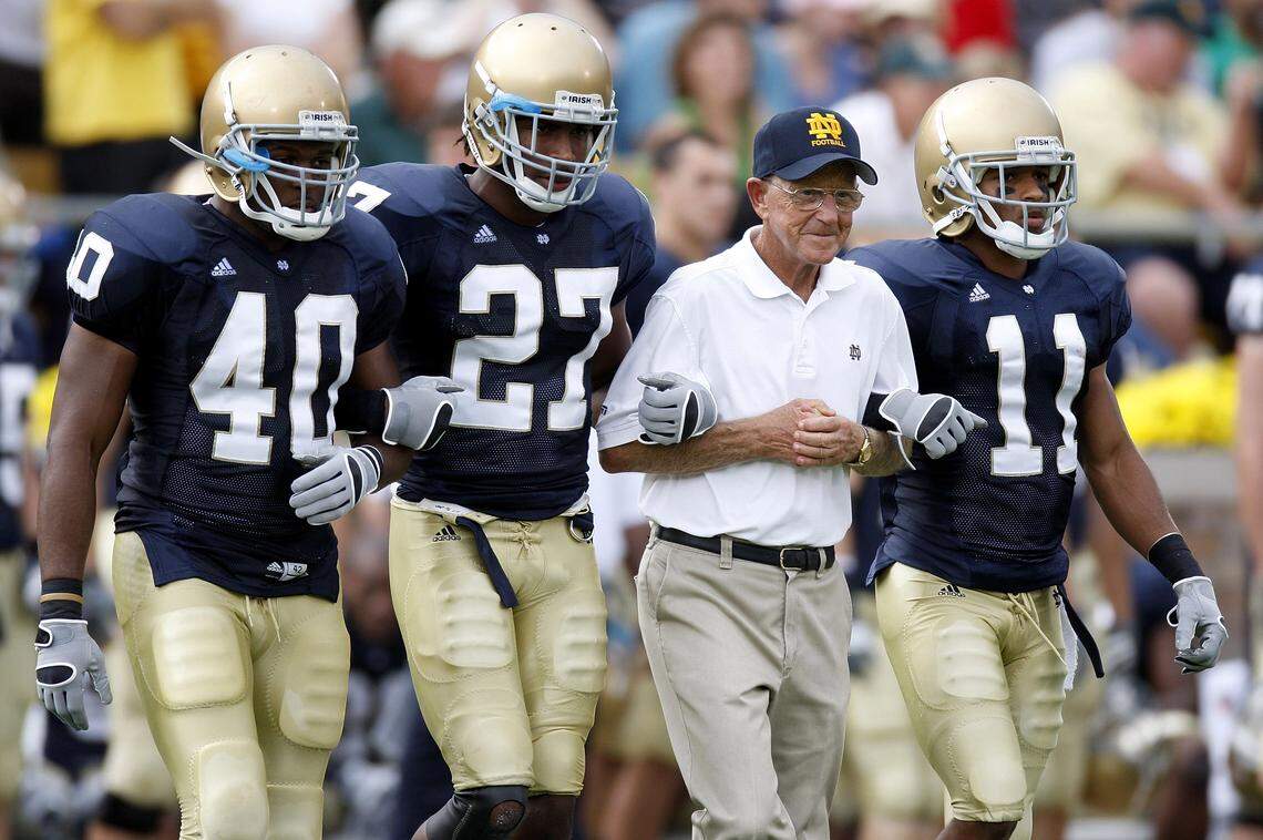 Former head coach Lou Holtz of the Notre Dame Fighting Irish walks out for the coin toss with David Grimes (11), David Bruton (27) and Maurice Crum (40) prior to playing the Michigan Wolverines on Sept. 13, 2008, at Notre Dame Stadium in South Bend, Indiana.