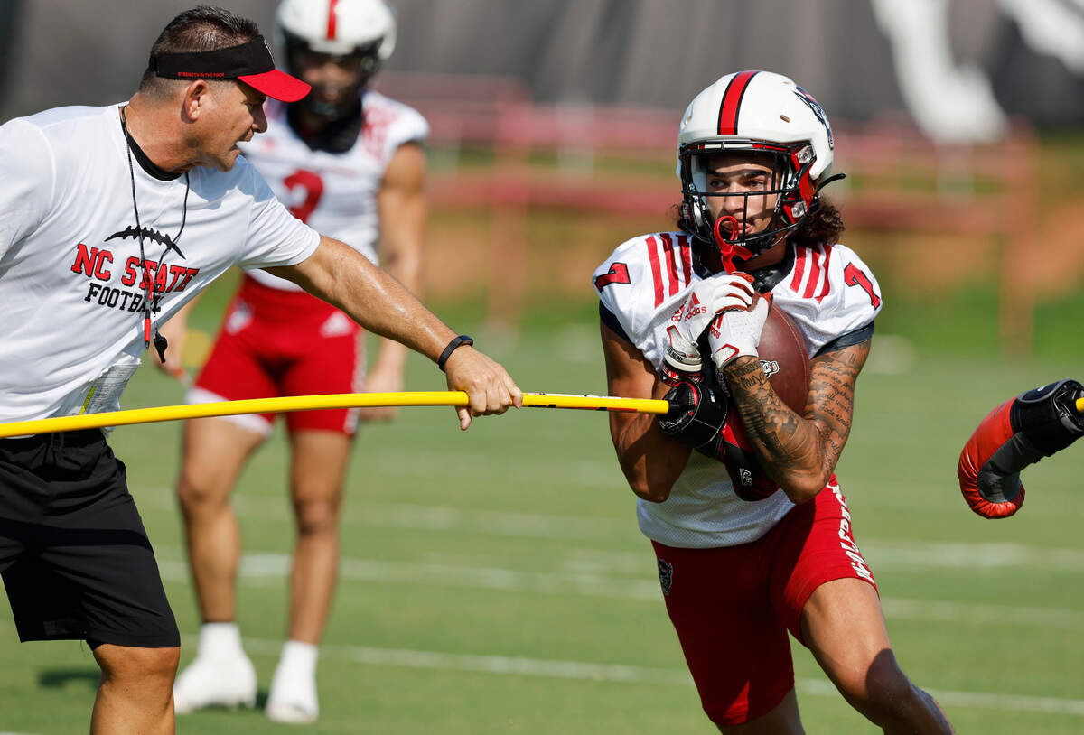 N.C. State offensive coordinator Tim Beck works with wide receiver Anthony Smith (7) during the Wolfpack’s first practice of fall camp in Raleigh, N.C., Wednesday, August 3, 2022.
