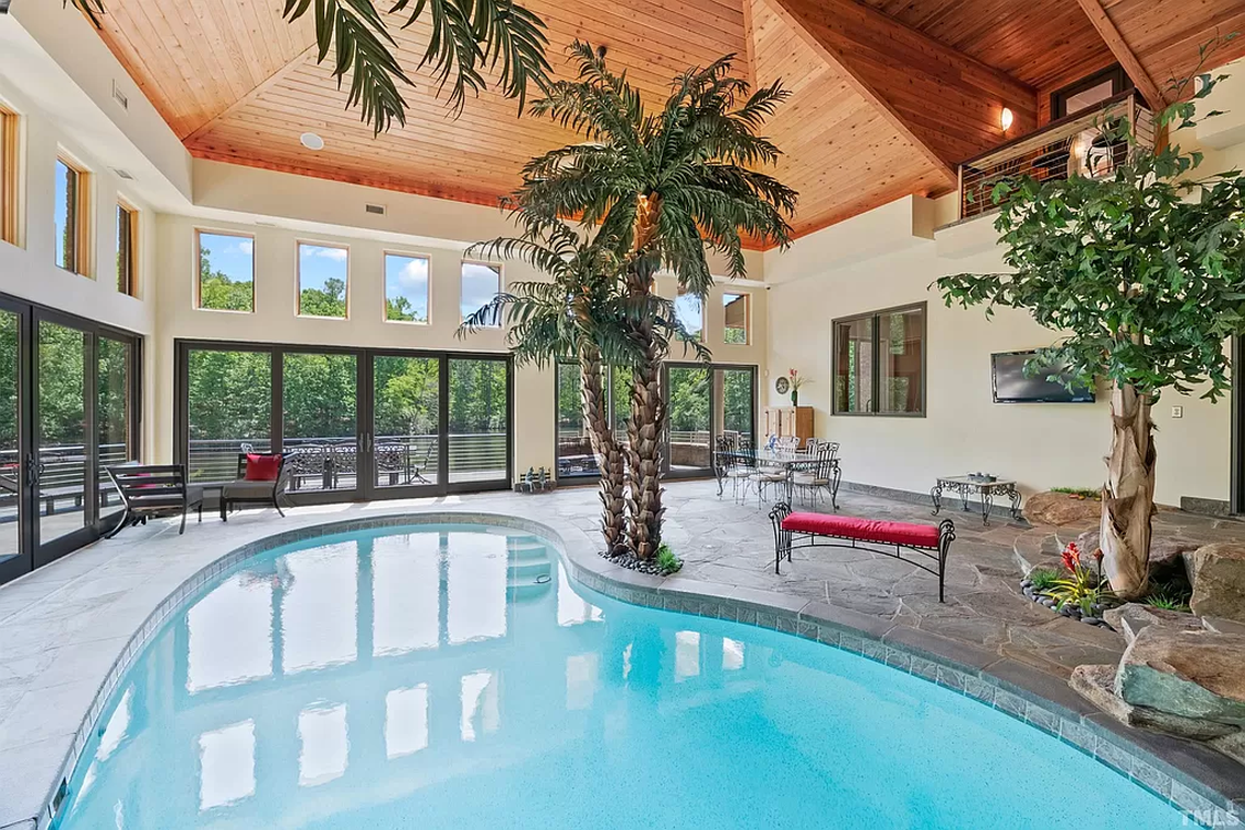 An indoor pool looks out onto the private lake.