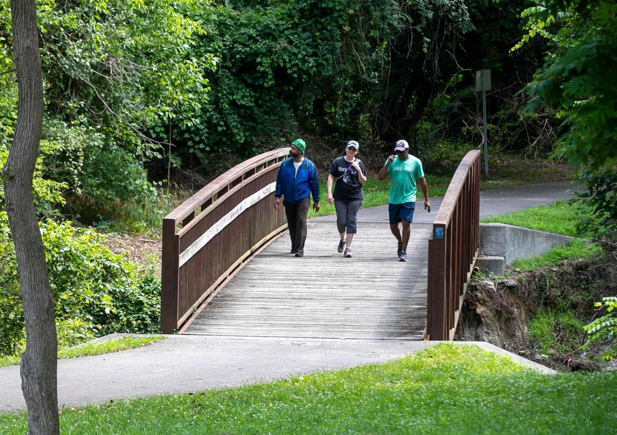 Daniel Chavis, Ann Marie Baum and Chico Scott walk on the Little Rock Trail, part of the Raleigh Greenway system that connects Chavis Park to the Walnut Creek Wetland Center and the Walnut Creek Greenway trail on Tuesday, June 15, 2021 in Raleigh, N.C.