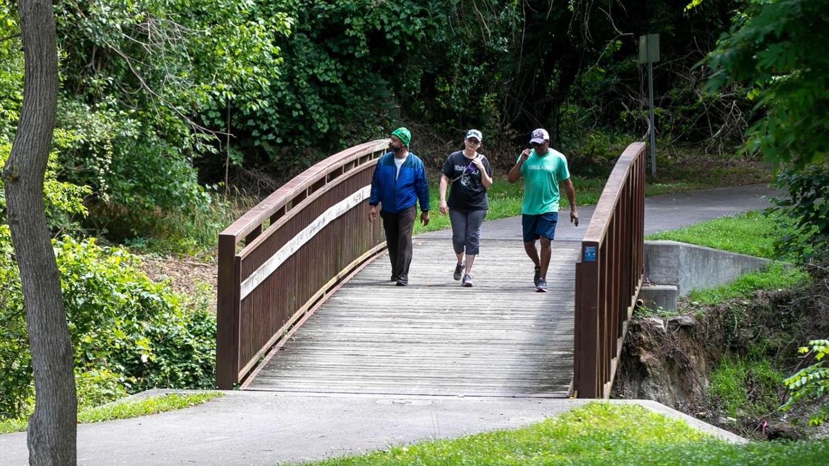 Daniel Chavis, Ann Marie Baum and Chico Scott walk on the Little Rock Trail, part of the Raleigh Greenway system that connects Chavis Park to the Walnut Creek Wetland Center and the Walnut Creek Greenway trail on Tuesday, June 15, 2021 in Raleigh, N.C.