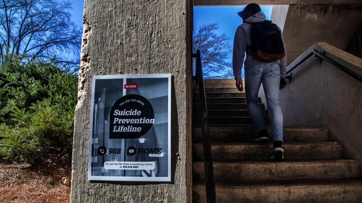 Signs, like this one spotted in a parking deck stairwell on N.C. State University’s main campus on on Feb. 13, 2022, advertise suicide prevention help. During the 2022-2023 academic year, NC State experienced a spate of 14 student deaths, including seven suicides.