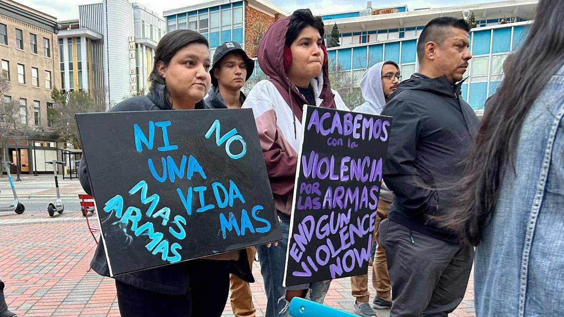 Glenda Polanco and Cecilia Polanco stand with signs denouncing gun violence during a vigil at the CCB Plaza in downtown Durham on Tuesday evening on March 29, 2023.
