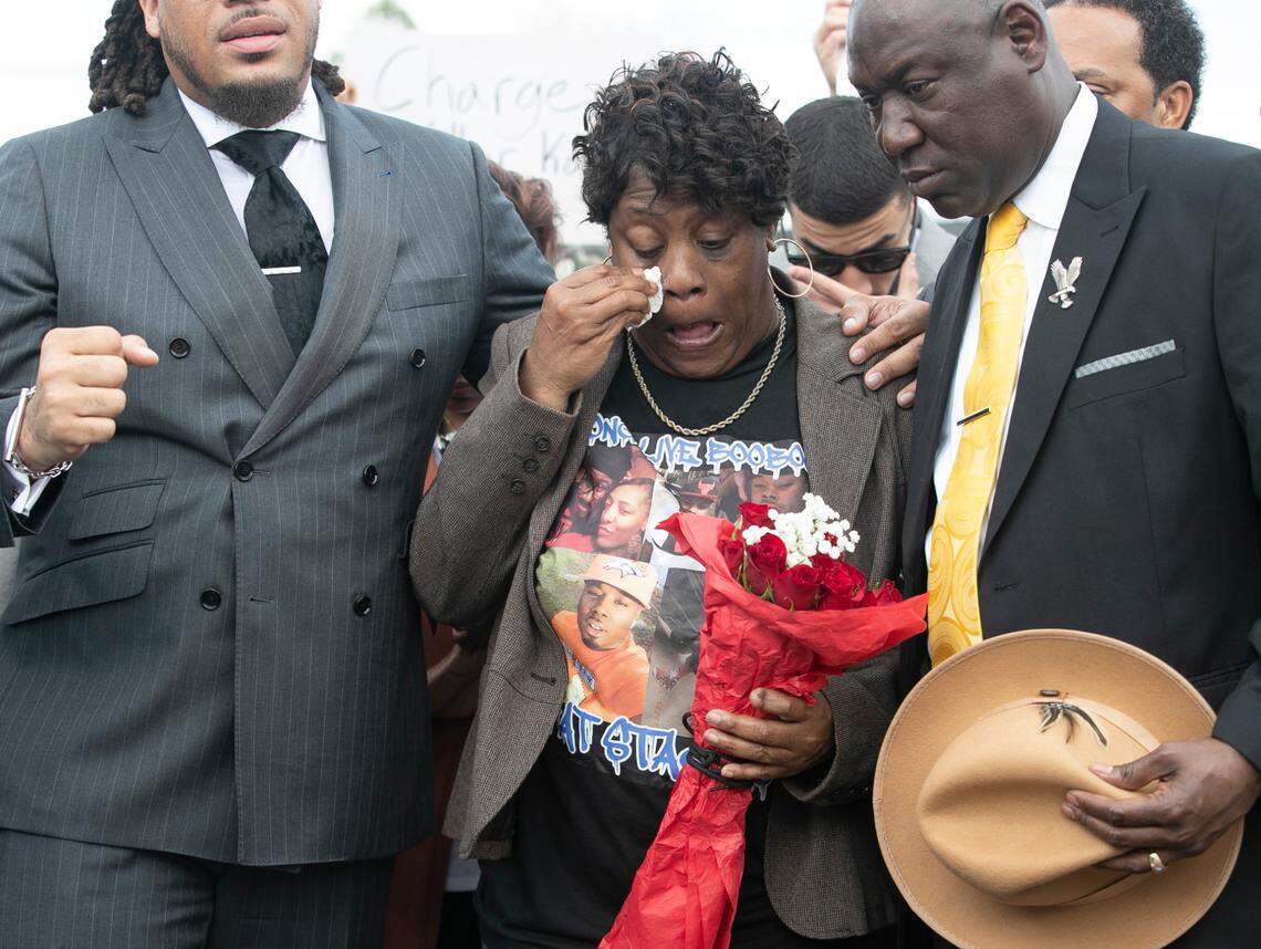 Sonya Williams, the mother of Darryl Williams, flanked by Rev. Greg Drumwright, left and civil rights attorney Ben Crump, wipes away tears before placing flowers on a memorial for her son on Rocky Quarry Road on Thursday, February 16. 2023 in Raleigh, N.C. Darryl Williams died after being tased by Raleigh police in January.