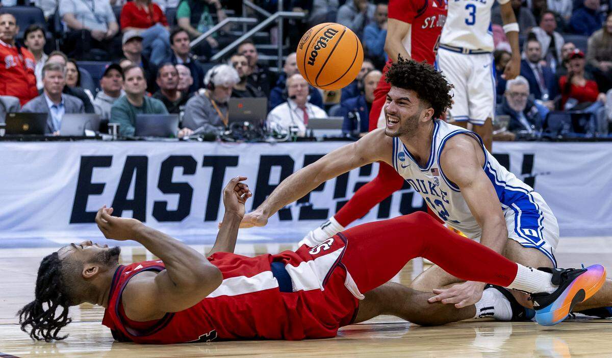 Duke forward Cameron Boozer (12) hits the court after drawing a foul from St. John’s forward Zuby Ejiofor (24) in the first half during the Sweet Sixteen of the NCAA Tournament on Friday, March 27, 2026, at Capital One Arena in Washington, D.C.