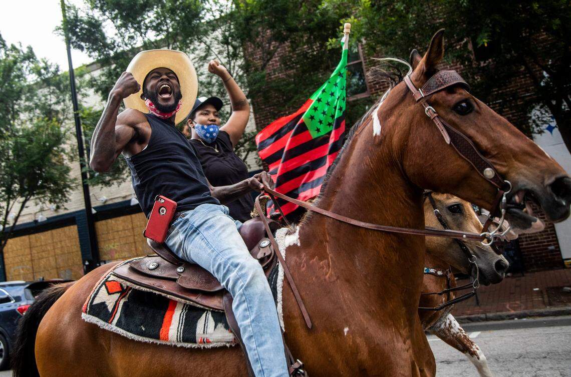 Greg Boykin and Candice Bann participate in a ride on horseback through downtown Raleigh Friday, June 19, 2020 in recognition of Juneteenth.