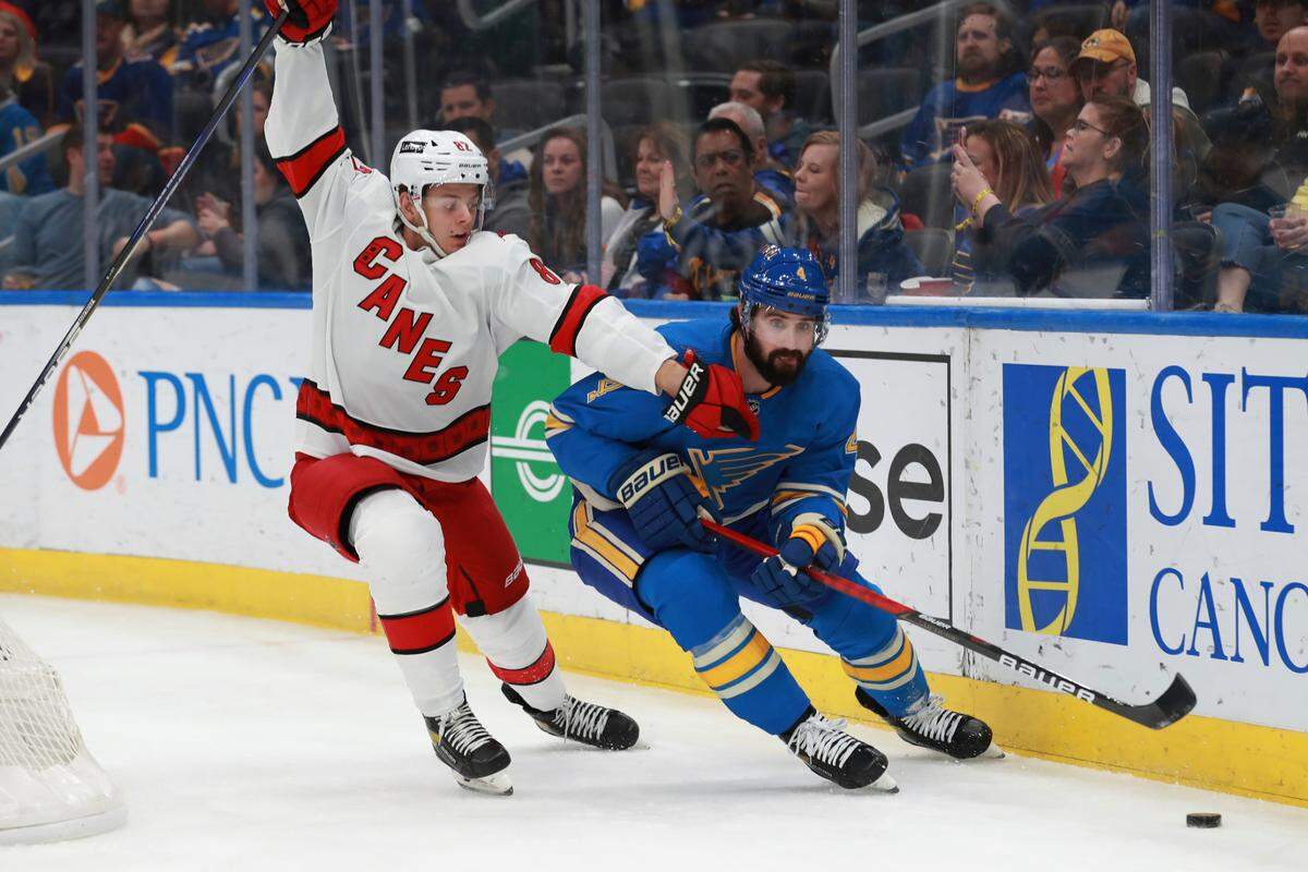 St. Louis Blues’ Nick Leddy (4) fights for the puck against Carolina Hurricanes’ Jesperi Kotkaniemi (82) during the first period of an NHL hockey game against Carolina Hurricanes the on Saturday, March 26, 2022 in St. Louis. (AP Photo/Michael Thomas)