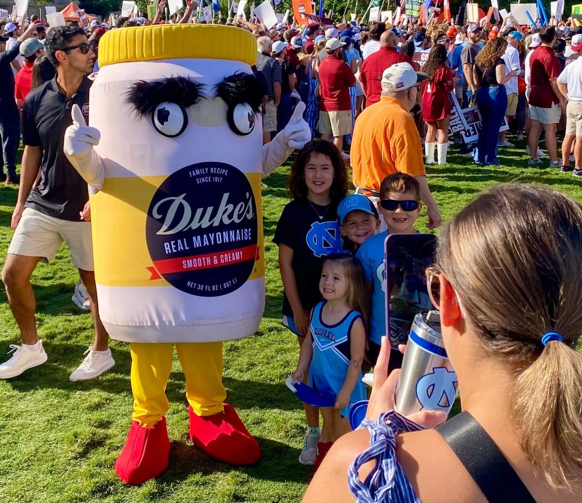 Fans pose with the Duke’s Mayo mascot while gathering to watch ESPN College GameDay on Saturday morning ahead of the Duke’s Mayo Classic, featuring UNC vs. South Carolina, in Charlotte, NC.
