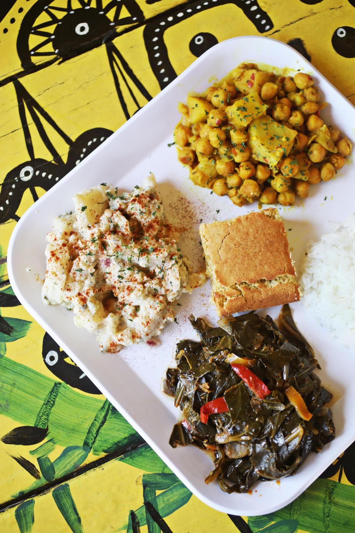 Soul Good Vegan Cafe in Durham cooks up a mean mess of collards served here on the curry chickpea platter alongside a pickle-punctuated potato salad, a mound of white rice and a square of sweet cornbread.