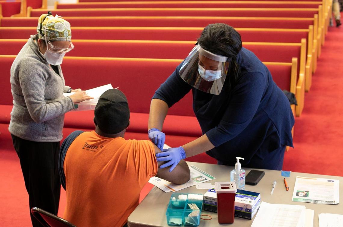Dr. Nerissa Price, right, prepares to vaccinate Curtis Richardson of Apex, N.C. during a COVID-19 vaccination clinic at New Bethel Christian Church on Saturday, February 6, 2021 in Raleigh, N.C.