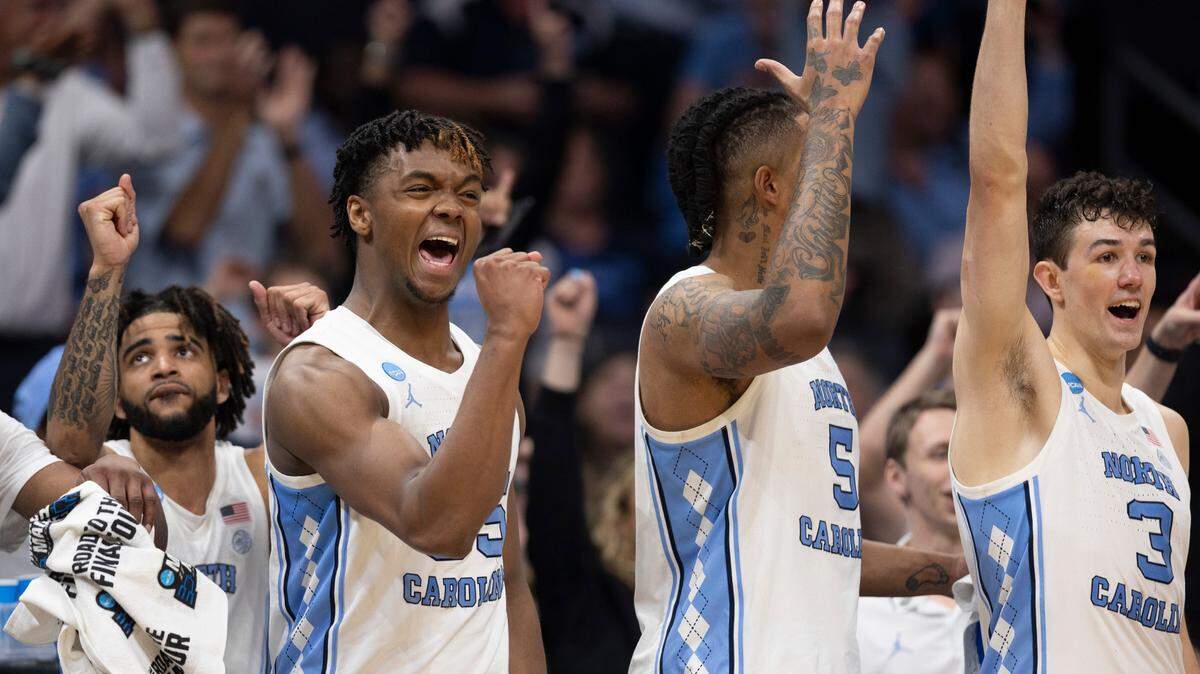 North Carolina’s R.J. Davis (4), Harrison Ingram (55), Armando Bacot (5) and Cormac Ryan (3) react after a basket by reserver player Rob Landry to give the Tar Heels’ a 90-61 lead in the final seconds of play against Wagner on Thursday, March 21, 2024 during the NCAA Tournament at Spectrum Center in Charlotte, N.C.