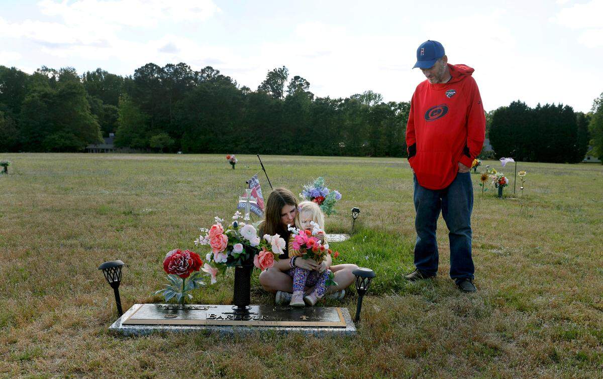 Van Barbour his daughters, Maddie, 12, and Oakleigh, 2, visit the grave of his wife and their mother who died from pregnancy-related complications in 2021.