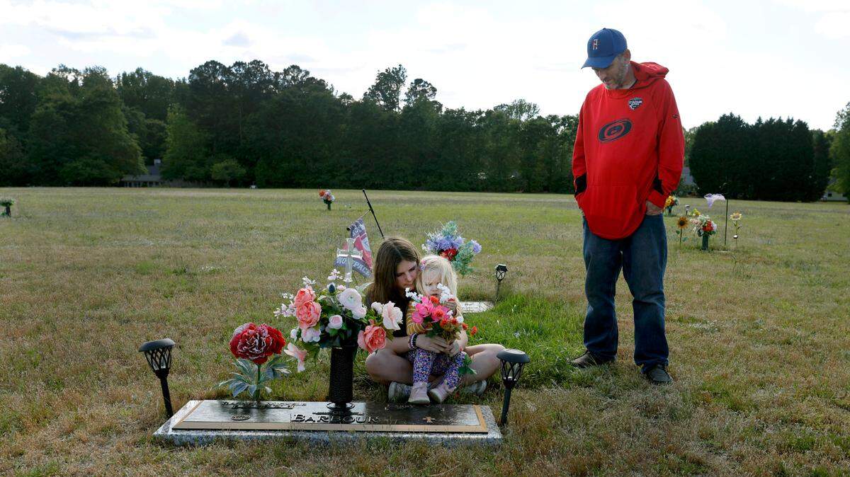Van Barbour his daughters, Maddie, 12, and Oakleigh, 2, visit the grave of his wife and their mother who died from pregnancy-related complications in 2021.