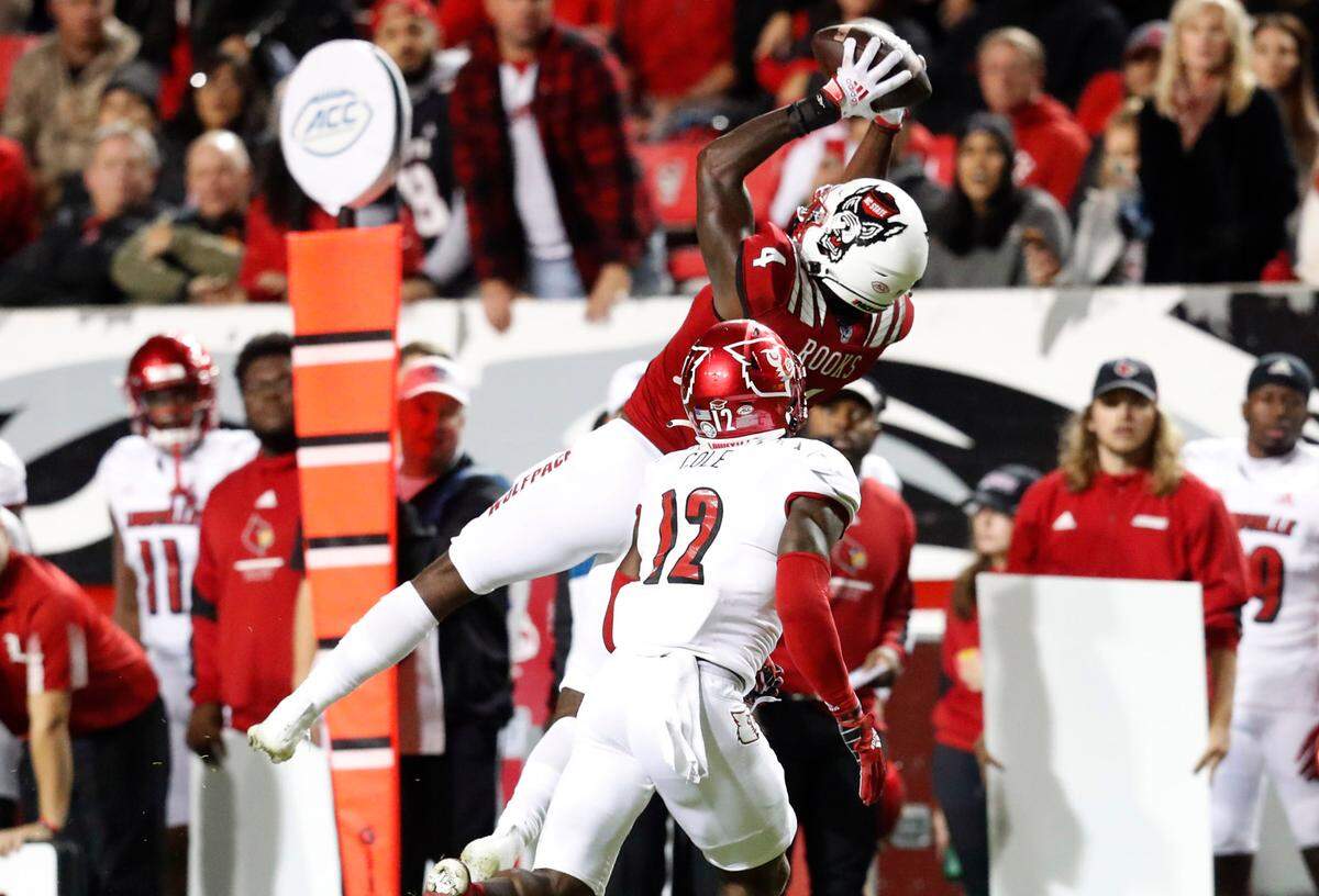 N.C. State wide receiver Porter Rooks (4) pulls in the reception as Louisville defensive back Qwynnterrio Cole (12) defends during the second half of N.C. State’s 28-13 victory over Louisville at Carter-Finley Stadium in Raleigh, N.C., Saturday, October 30, 2021.