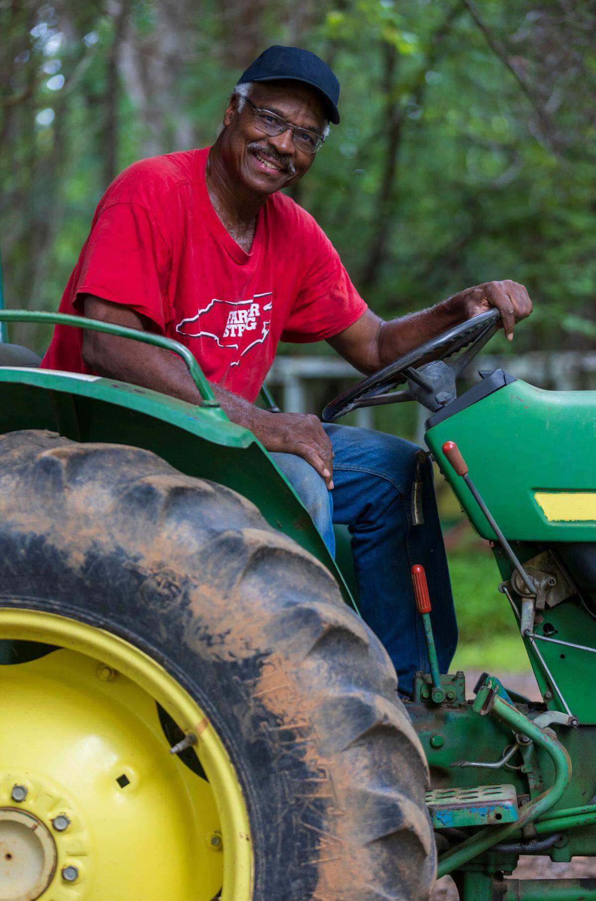 Tom Savage poses for a portrait on his tractor on Thursday, September 8, 2022 at Allied Organic Farms in Hurdle Mills, N.C.