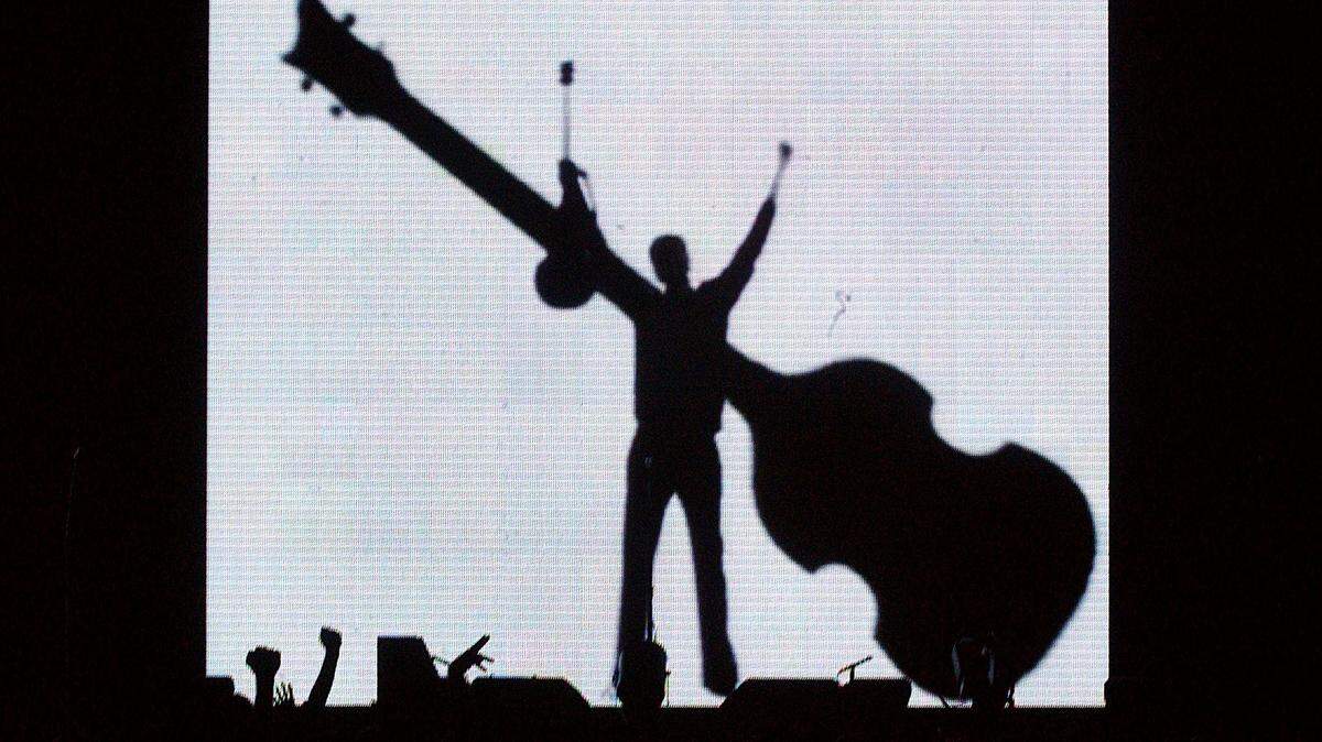 Paul McCartney is silhouetted in bright lights onstage as his concert begins at the RBC Center in Raleigh on Oct. 7, 2002.