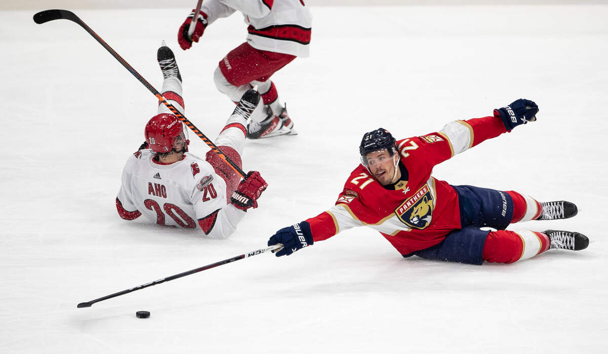 The Florida Panthers Nick Cousins (21) reaches for the puck after checking the Carolina Hurricanes Sebastian Aho (20) in the third period during the Eastern Conference Finals on Wednesday, May 24, 2023 at FLA Live Arena in Sunrise, Fla.