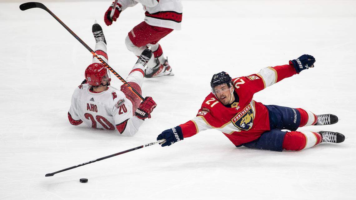 The Florida Panthers Nick Cousins (21) reaches for the puck after checking the Carolina Hurricanes Sebastian Aho (20) in the third period during the Eastern Conference Finals on Wednesday, May 24, 2023 at FLA Live Arena in Sunrise, Fla.