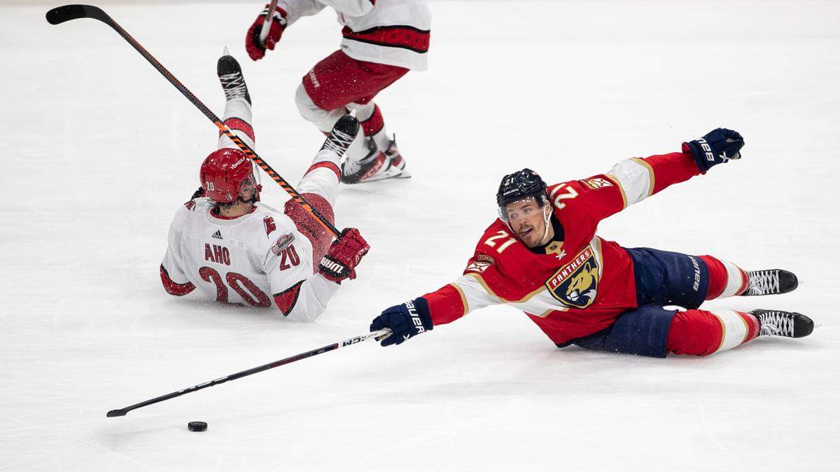 The Florida Panthers Nick Cousins (21) reaches for the puck after checking the Carolina Hurricanes Sebastian Aho (20) in the third period during the Eastern Conference Finals on Wednesday, May 24, 2023 at FLA Live Arena in Sunrise, Fla.