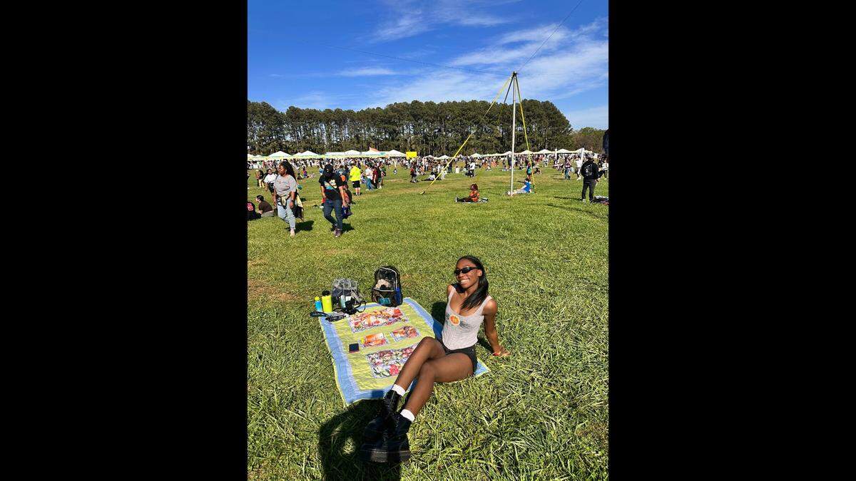 Alexia Heath poses on the grassy fields at Dorothea Dix Park during Dreamville Festival.