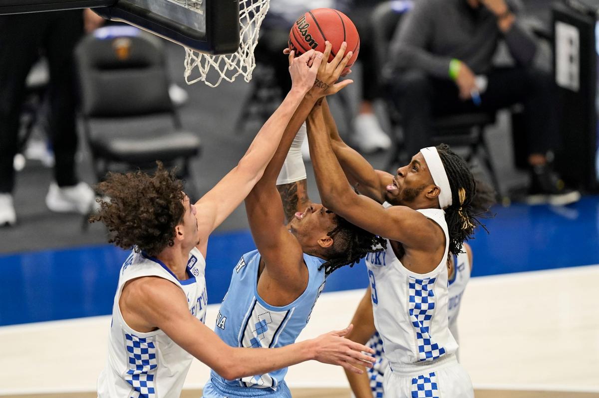 Kentucky’s Lance Ware, left, and Kentucky’s Isaiah Jackson, right, put pressure on North Carolina’s Armando Bacot, center, the first half of an NCAA college basketball game, Saturday, Dec. 19, 2020, in Cleveland.