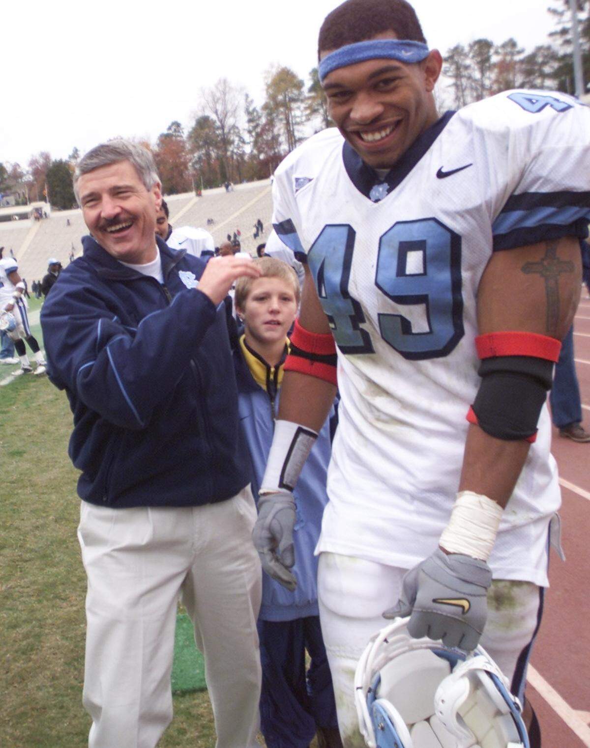 North Carolina’s head coach Carl Torbush celebrates victory with Defensive End Julius Peppers after Carolina’s definitive trouncing of Duke with a score of 59 to 21 in 2000.