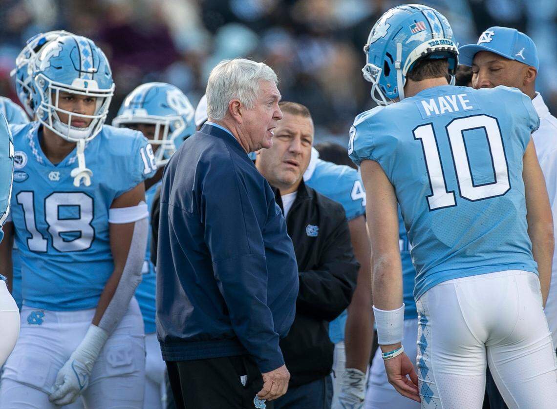 North Carolina coach Mack Brown and offensive coordinator Phil Longo confer with quarterback Drake Maye (10) in the fourth quarter against Wofford on Saturday, November 20, 2021 at Kenan Stadium in Chapel Hill, N.C.